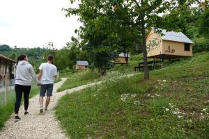 two people walking down a gravel path with a building at Casa Baladin camere di Charme e Agronidi dell'Open Garden in Piozzo