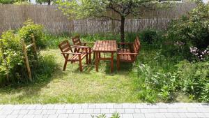 una mesa y sillas en un jardín con un árbol en Miodowa en Zwierzyniec