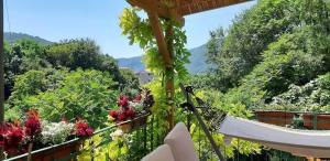 a hammock on a balcony with trees and flowers at La Casa Rosa di Segusino with SPA Jacuzzi in garden in Sequsino