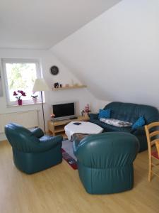 a living room with two blue couches and a tv at Münsterblick in Bad Doberan