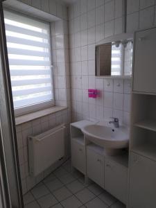 a white bathroom with a sink and a mirror at Münsterblick im Rosenwinkel in Bad Doberan +7 photos