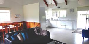 sala de estar con sofá y cocina en Pitcairn House en Burnt Pine