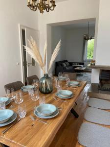 una mesa de madera con platos y copas de vino. en Wunderschöne sanierte Wohnung vor den Toren Kölns, en Colonia