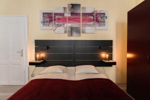 a bedroom with a large black headboard and two lamps at Radiant Premium Apartments - Fünfhaus in Vienna