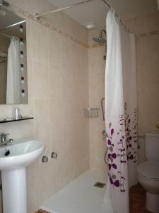 a bathroom with a sink and a shower curtain at Hostal Castilla in Serón de Nájima