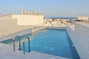 a swimming pool on the roof of a building at Moderno Apartamento SCANDIC, Playa Del Cura in Torrevieja