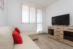 un soggiorno con divano bianco e TV a schermo piatto di Apartment STIKOVAC a Šilo