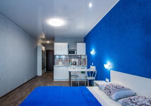 a blue room with a bed and a kitchen at 22-HOTEL in Barnaul