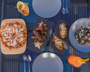 a table with plates of food and a pizza at Amari Hua Hin in Hua Hin
