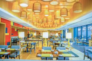 a restaurant with tables and chairs and windows at Amari Hua Hin in Hua Hin