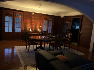 sala de estar con mesa, sillas y sofá en Chez Antonin, en Bouillante