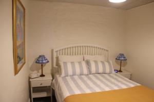 a bedroom with a bed with two lamps on night stands at Victoria Cottage in Robe