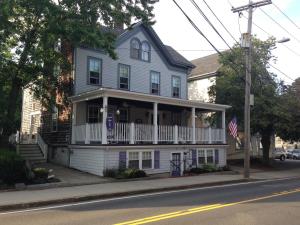 a white house with a balcony on a street at Lantana House in Rockport