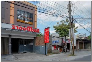 an empty street with a building with a sign on it at RedDoorz near Jogja Expo Center 2 in Yogyakarta
