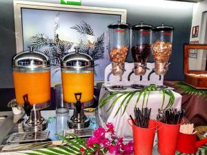 un grupo de tres frascos de vidrio con bebidas en un mostrador en Hotel Exsel Floralys, en Étang-Salé les Bains