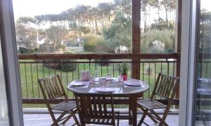 d'une table et de chaises sur un balcon avec vue sur le jardin. dans l'établissement T2 Antigua Ondres plage avec piscine et tennis, à Ondres