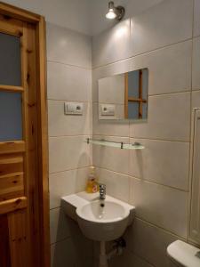a white bathroom with a sink and a mirror at Apartamenty i pokoje gościnne "Wacuś" in Srebrna Góra +94 photos
