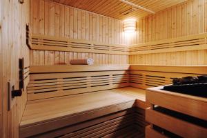 a sauna with wood paneling and a light in it at Hotel Legenda in Toruń