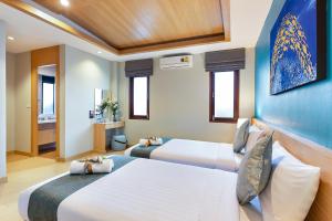 two beds in a hotel room with two beds at Lady Naya Villas - SHA Extra Plus in Rawai Beach