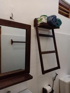 a bathroom with a mirror and a shelf with towels at Garden Cottage Arugambay in Arugam Bay