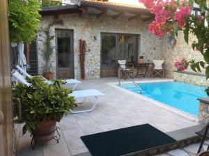 um pátio com piscina, mesa e cadeiras em Villa Lithos Parga em Parga