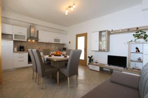 una cucina e una sala da pranzo con tavolo e sedie di Apartment Car Marica a Šilo