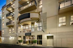 ein Apartmenthaus mit Balkon auf einer Straße in der Unterkunft Melbourne Carlton Central Apartment Hotel Official in Melbourne