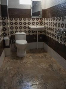 La salle de bains est pourvue de toilettes et d'un lavabo. dans l'établissement Sherpa Residency, à Darjeeling