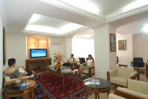 a group of people sitting in a living room watching tv at Bodrum Marma Otel in Bodrum City