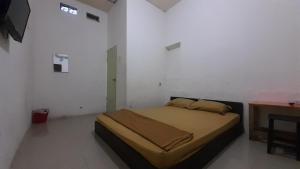 Un dormitorio con una cama y una mesa. en Rumah Rahman Syari'ah, en Bekasi