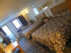 a hotel room with two beds and a table at Midtown Western Inn - Kearney in Kearney