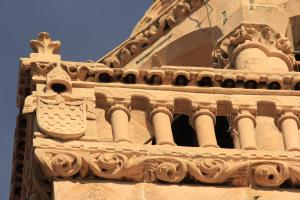 a building with a crest on the side of it at Guest House Dijana in Korčula
