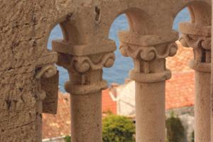 a view of the ocean through the archways of a building at Guest House Dijana in Korčula