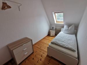 a small bedroom with a bed and a dresser at Moderne Ferienwohnung in ruhiger Lage in Neetze
