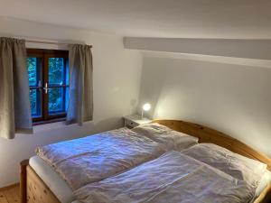 un letto in una camera da letto con finestra di Ferienhaus Juster im Wald a Gutenbrunn