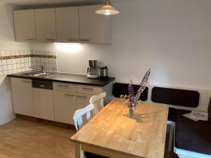 a kitchen with a wooden table with a vase of flowers on it at Ferienhaus Juster im Wald in Gutenbrunn