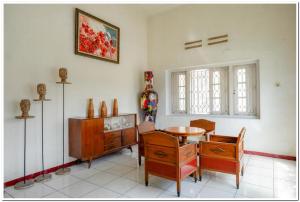 a living room with a table and some chairs and a table and a tablektop at RedDoorz @ Prawirotaman in Yogyakarta