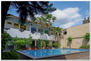 a building with a swimming pool in front of a building at RedDoorz @ Prawirotaman in Yogyakarta