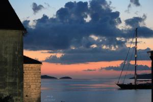 a boat sitting in the water at sunset at Guest House Dijana in Korčula