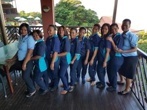 un grupo de mujeres con uniformes azules de pie en una cubierta en ANEW Hotel Ocean Reef Zinkwazi, en Zinkwazi Beach