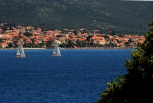 two sailboats in a large body of water with a town at Guest House Dijana in Korčula