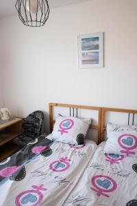 ヤストシェンビャ・グラにあるDom Gościnny Cumaのベッドルーム1室(ピンクとブルーのサインが入ったベッド1台付)