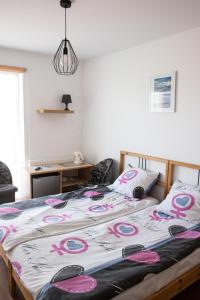 ヤストシェンビャ・グラにあるDom Gościnny Cumaのベッドルーム1室(ピンクと白のシーツが備わるベッド1台付)