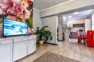 a living room with a large tv and a kitchen at 435 Апартаменты в центре для командированных и туристов in Almaty