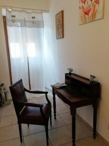 uma cadeira e um piano num quarto em La piazzetta em Pignola