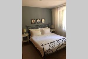 een slaapkamer met een bed met witte lakens en een raam bij apartman Dunja in Novi Vinodolski