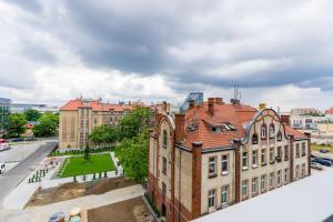 a large brick building with a red roof at Apartments Poznan Towarowa by Renters in Poznań