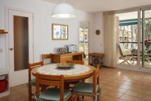 a kitchen and dining room with a table and chairs at AT141 Els Pins, comunidad con piscina en primera línea in Torredembarra