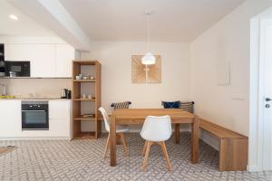 eine Küche und ein Esszimmer mit einem Holztisch und Stühlen in der Unterkunft BLAU Apartamento en Cala Galiota con vistas al mar in Colonia Sant Jordi + 9 Fotos