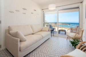 ein Wohnzimmer mit Couch und Blick aufs Meer in der Unterkunft BLAU Apartamento en Cala Galiota con vistas al mar in Colonia Sant Jordi